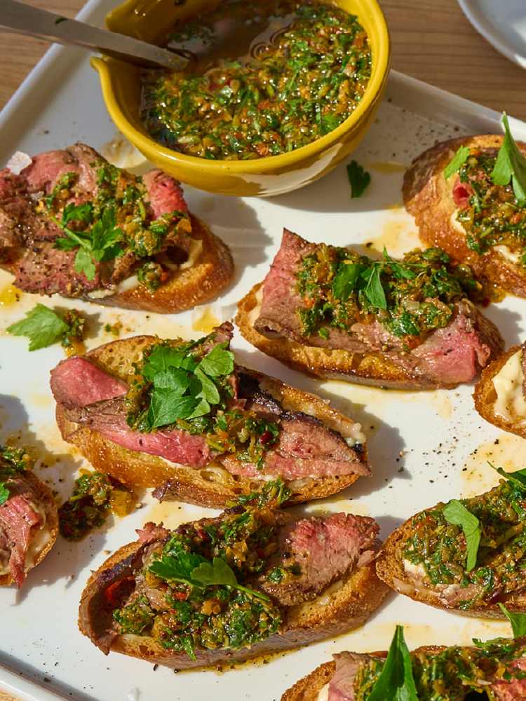 Grilled lamb crostini topped with preserved lemon salsa verde and fresh parsley