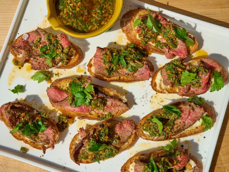 Grilled lamb crostini topped with preserved lemon salsa verde on toasted bread