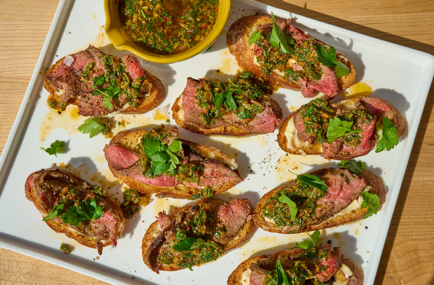 Grilled lamb crostini topped with preserved lemon salsa verde on toasted bread