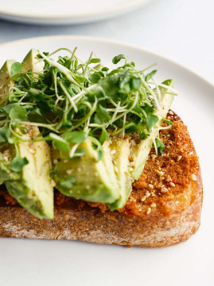 California Lamb avocado toast served with lemon and fresh microgreens