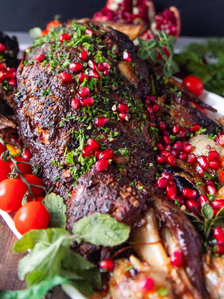 Roasted lamb shoulder sliced and served with fresh herbs
