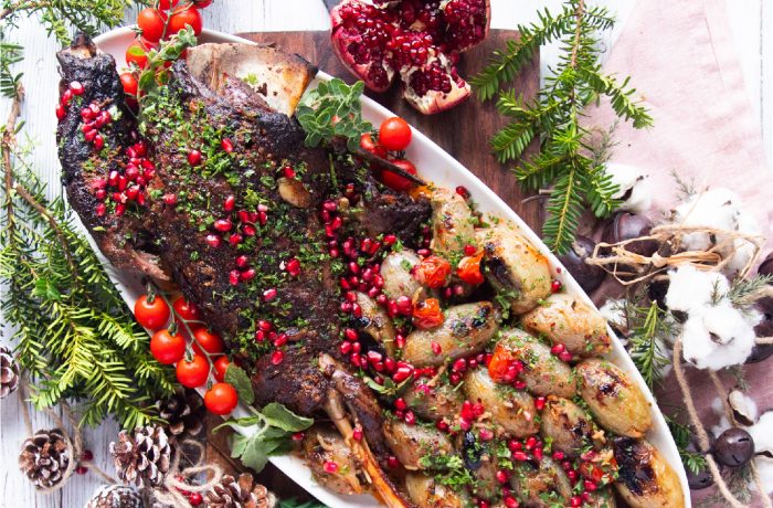 Pomegranate Molasses Lamb Shoulder Roast served on a white platter with pomegranate seed