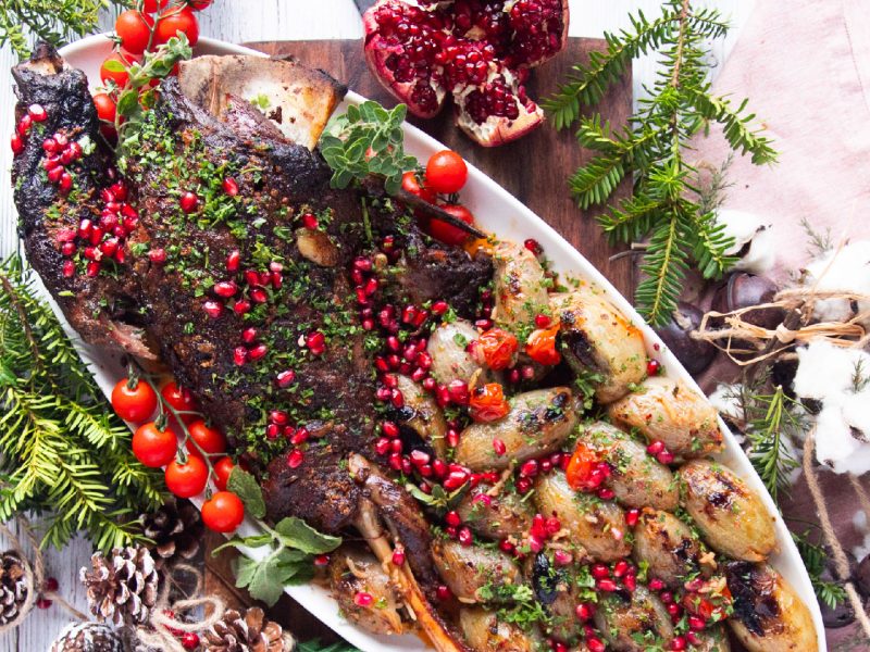 Pomegranate Molasses Lamb Shoulder Roast served on a white platter with pomegranate seed