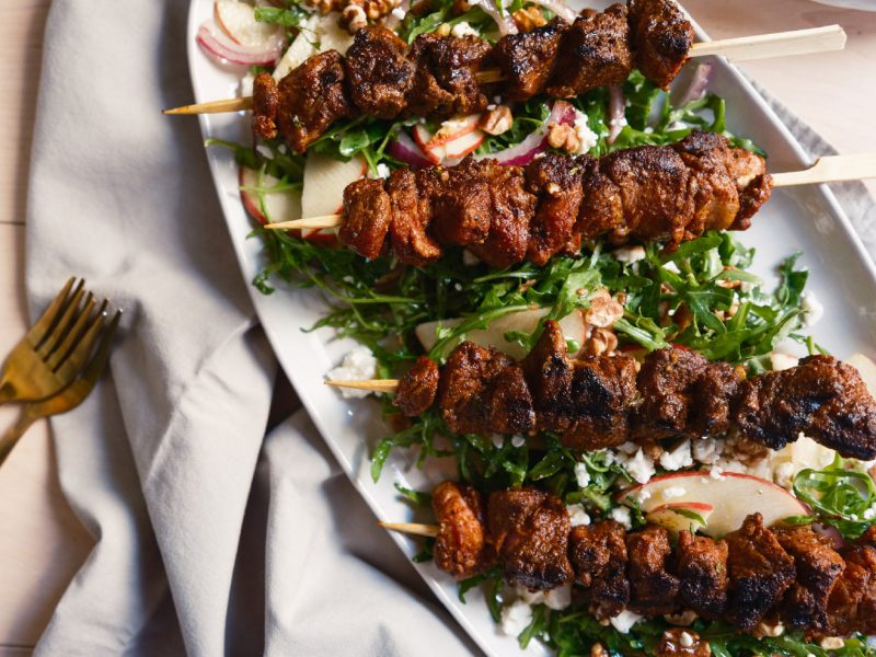 Pumpkin Spiced Lamb Kebabs served over an apple and arugula salad with walnuts, red onion, and crumbled goat cheese.