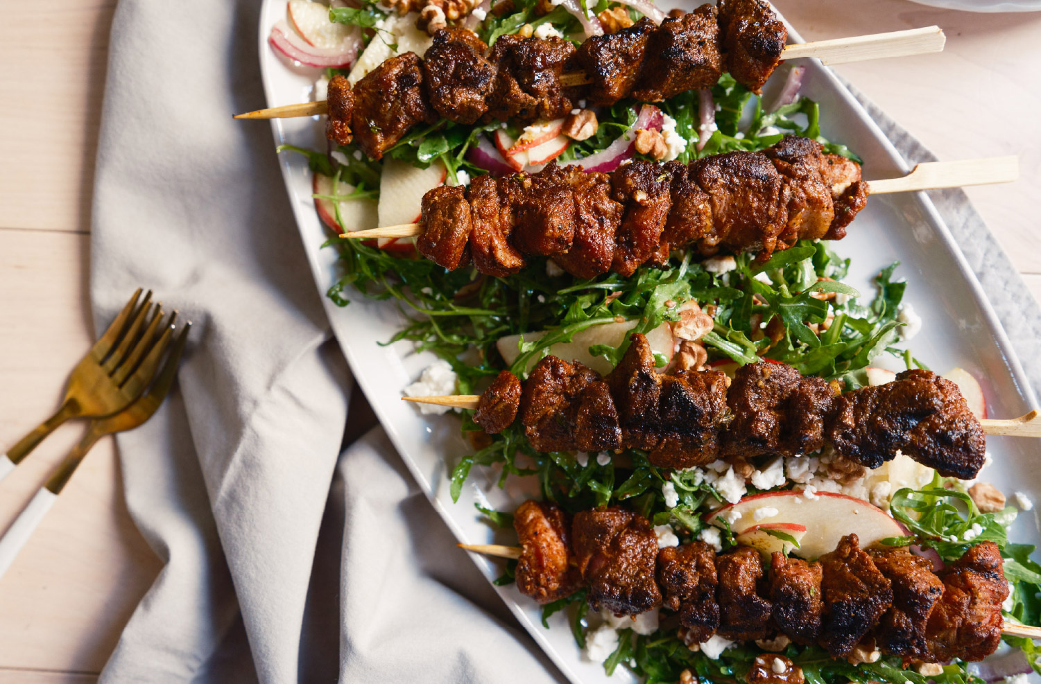 Pumpkin Spiced Lamb Kebabs served over an apple and arugula salad with walnuts, red onion, and crumbled goat cheese.
