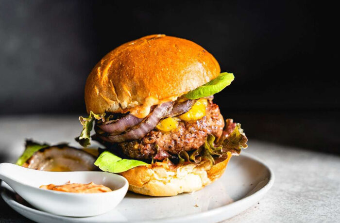 Plated lamb burger and side sauce
