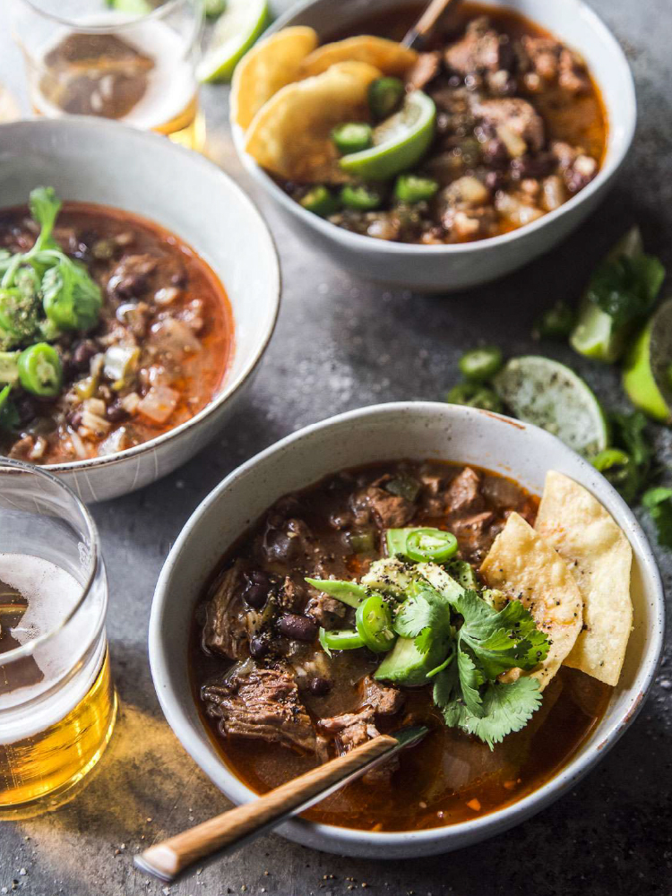California Lamb shoulder cooking in a slow cooker with enchilada sauce and black beans