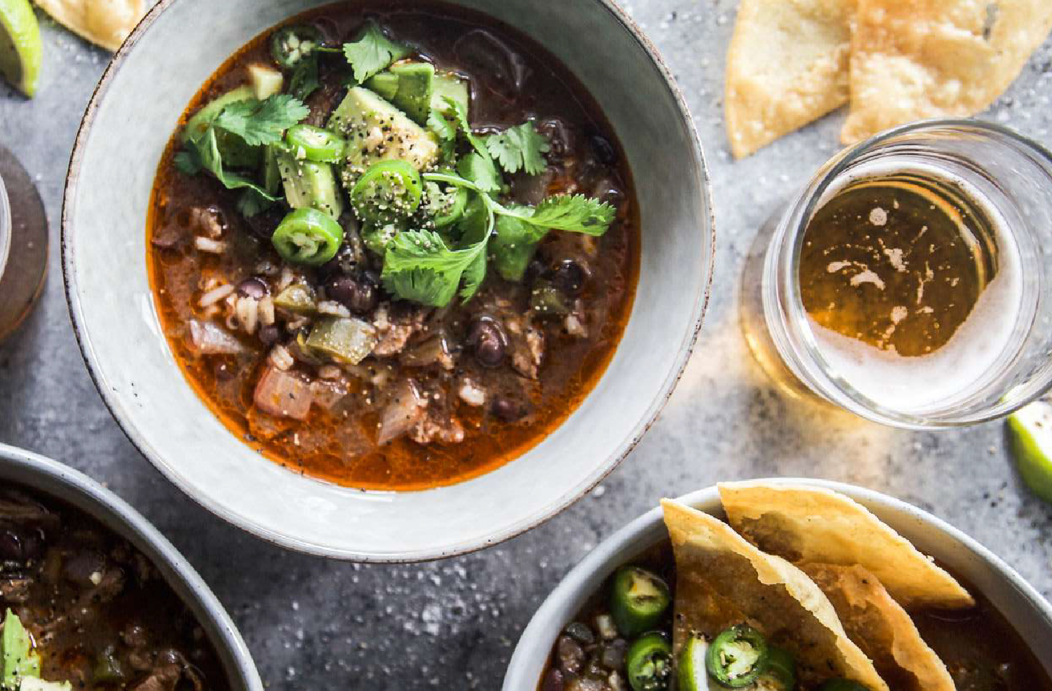 Slow cooker lamb shoulder Tex Mex tortilla soup with cilantro and tortilla chips in serving bowls
